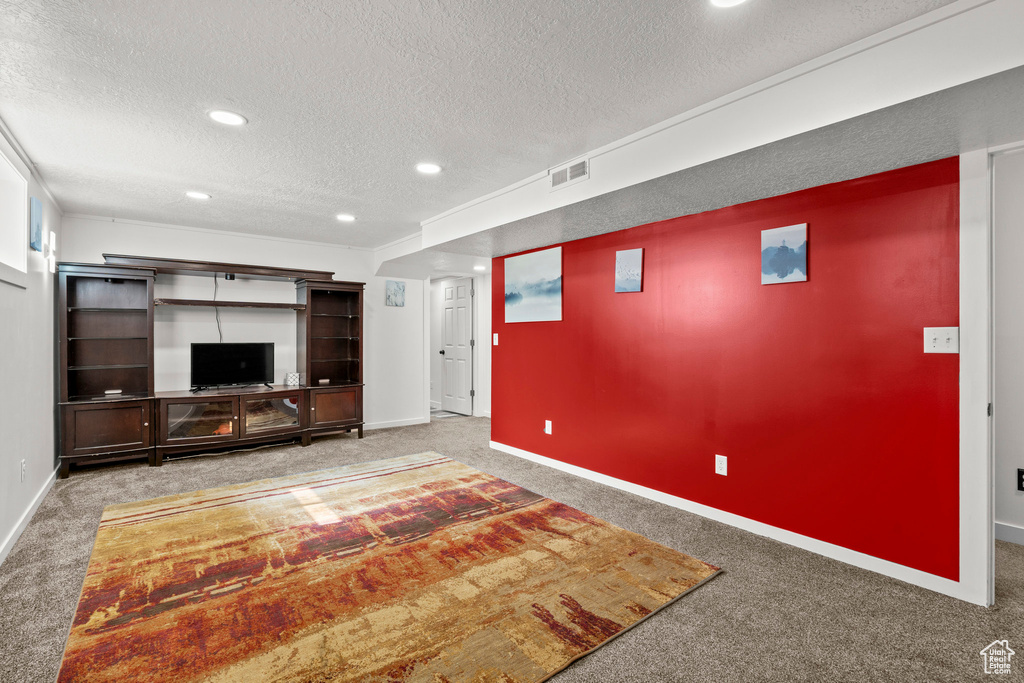 Unfurnished living room with carpet flooring, a textured ceiling, baseboards, and recessed lighting