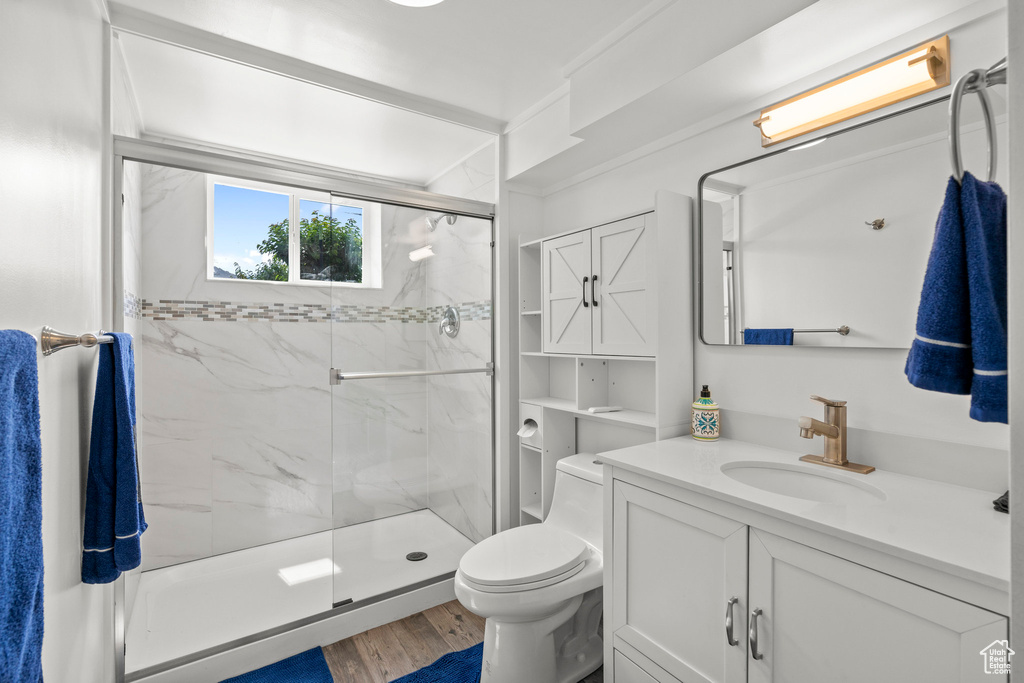 Full bathroom featuring toilet, a marble finish shower, vanity, and wood finished floors