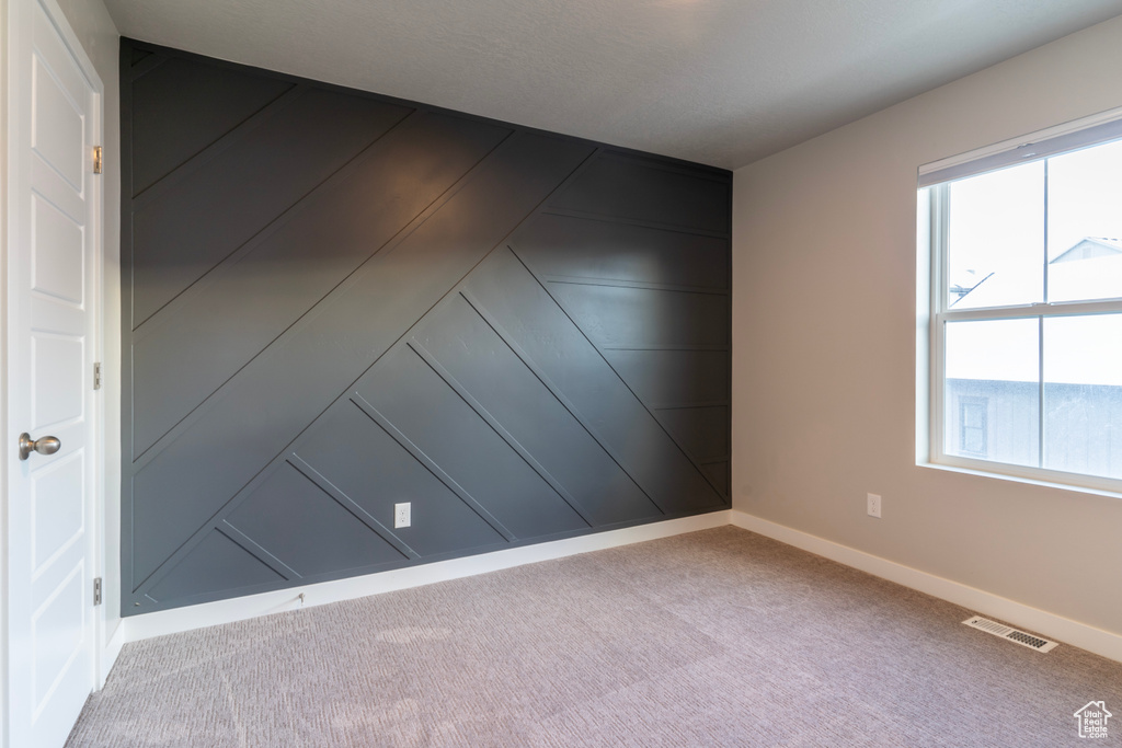 Unfurnished room featuring baseboards and carpet