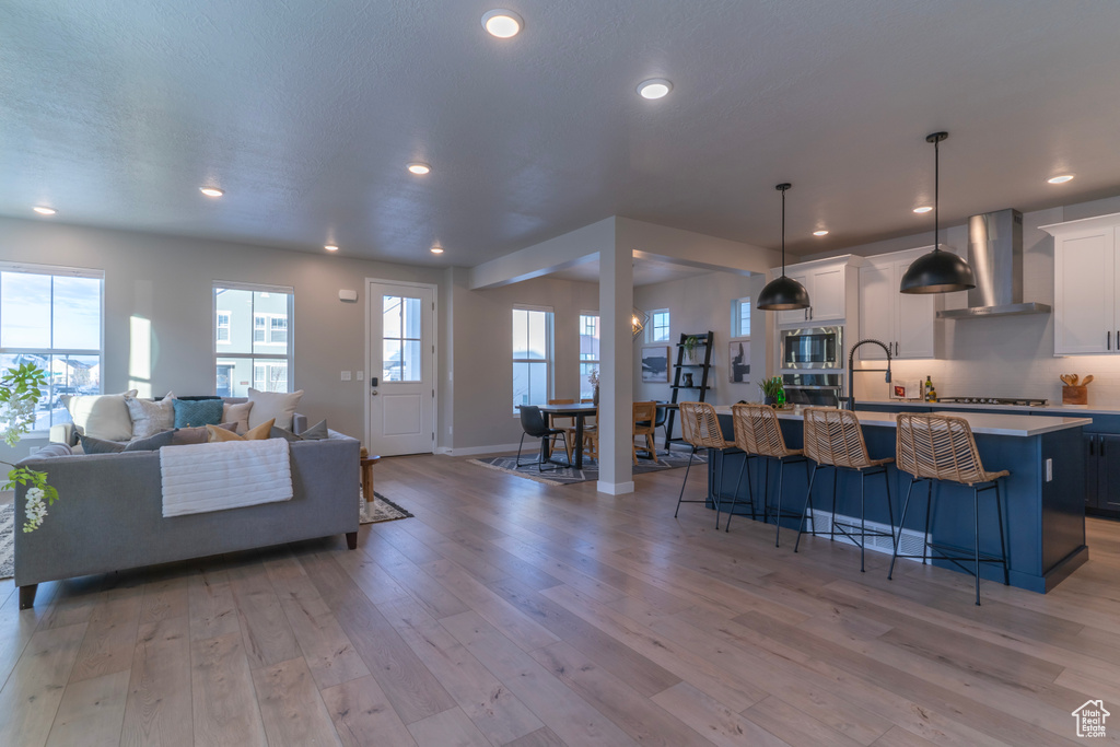 Living area featuring light wood-style flooring, recessed lighting, and baseboards