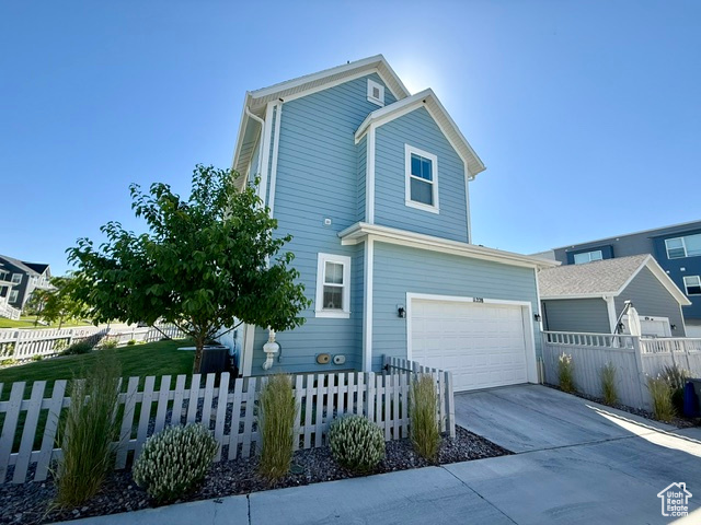 View of home\\\'s exterior featuring a garage, driveway, and a fenced front yard