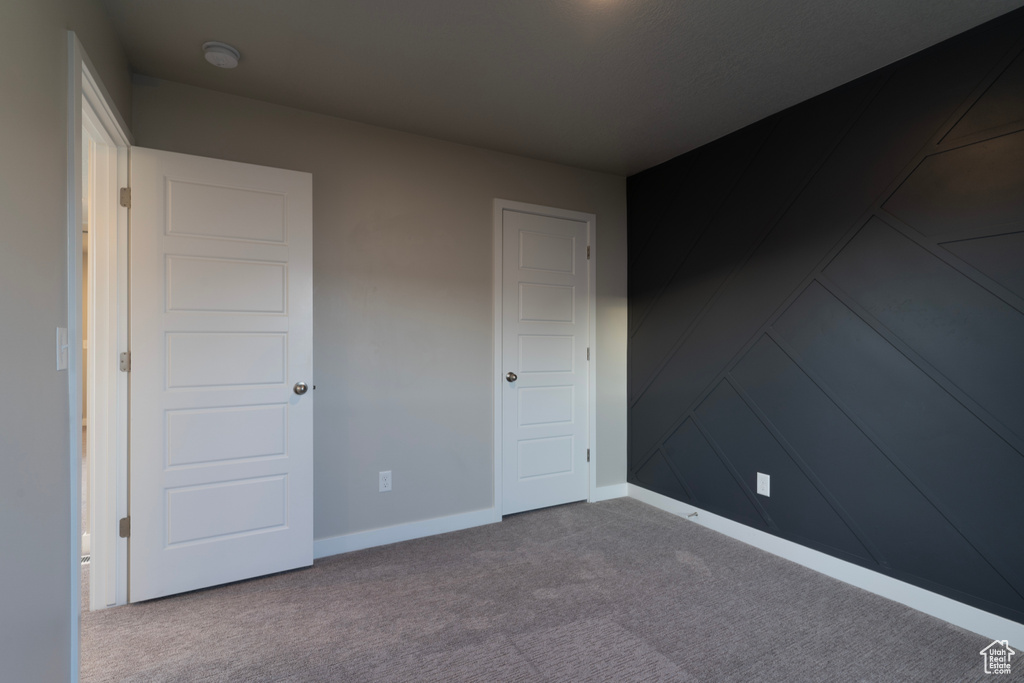 Unfurnished bedroom with carpet floors and baseboards
