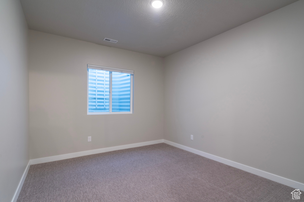 Carpeted spare room with baseboards