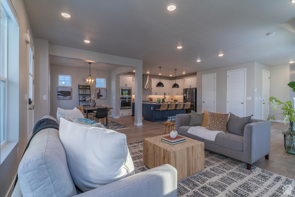 Living room with light wood-style floors, recessed lighting, and baseboards