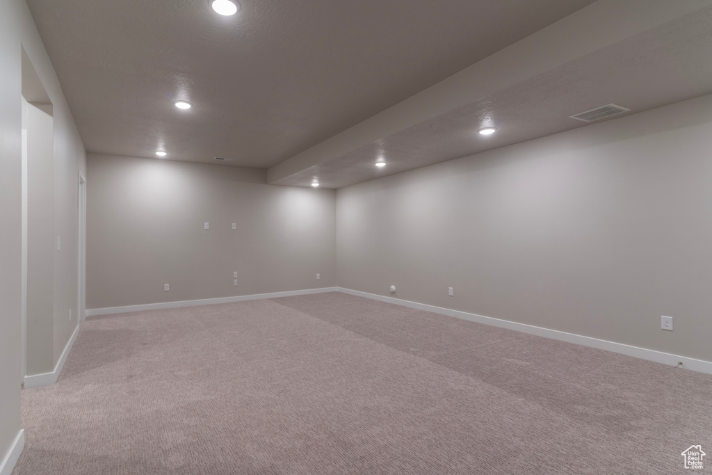 Spare room featuring recessed lighting, light colored carpet, and baseboards