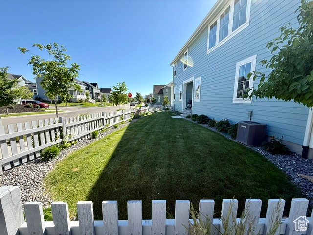 View of yard with cooling unit and a residential view