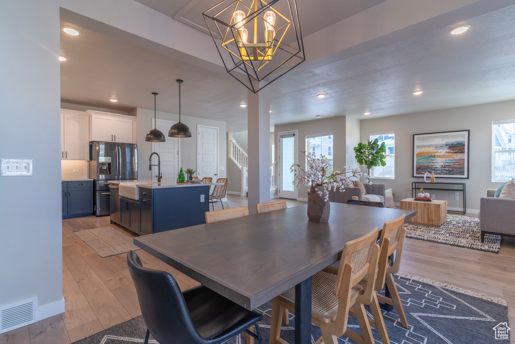 Dining area featuring healthy amount of natural light, light wood-type flooring, baseboards, recessed lighting, and stairs