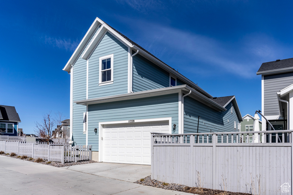 View of front of house with concrete driveway and a garage