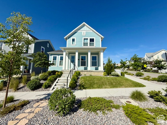 View of front of house with a porch and a front yard