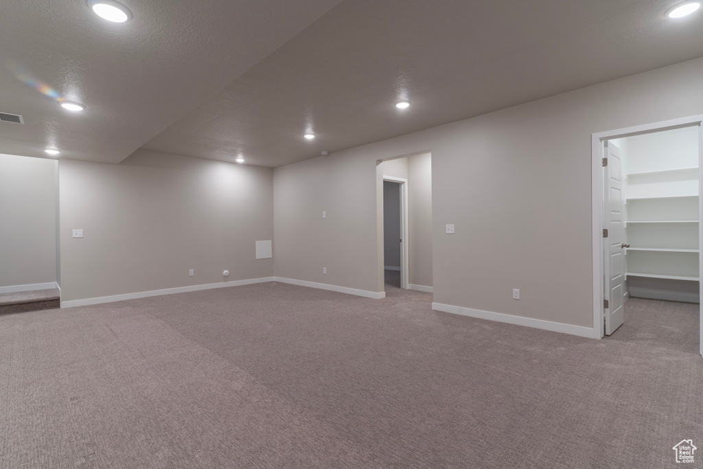 Finished basement featuring light colored carpet, baseboards, and recessed lighting