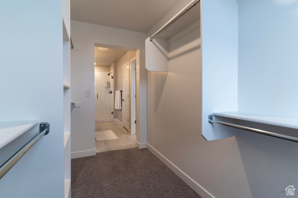 Spacious closet featuring light colored carpet and light tile patterned flooring