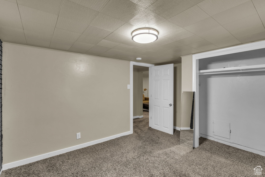 Unfurnished bedroom with carpet flooring, a closet, and baseboards