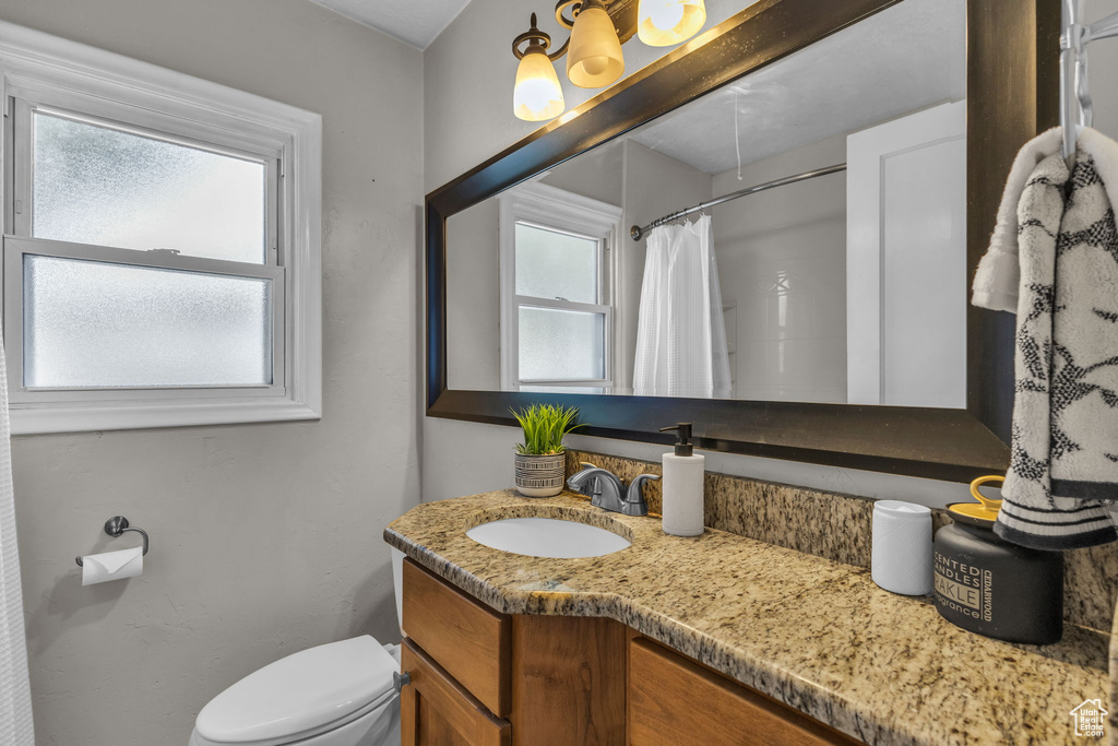 Full bathroom with vanity, toilet, and a shower with curtain