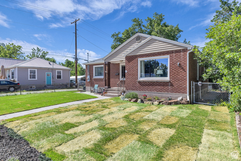 Bungalow featuring brick siding