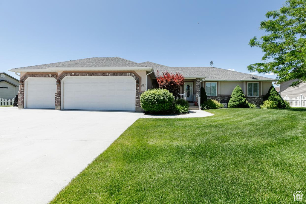 Ranch-style home featuring an attached garage, concrete driveway, stone siding, and stucco siding