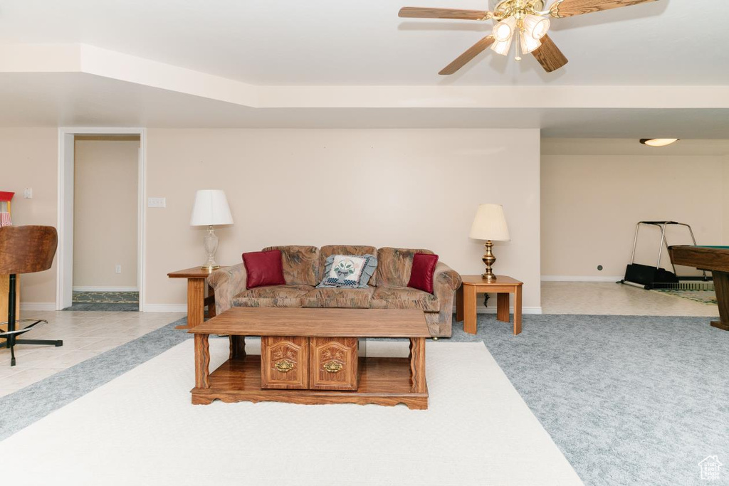 Living room featuring a ceiling fan, baseboards, and carpet flooring