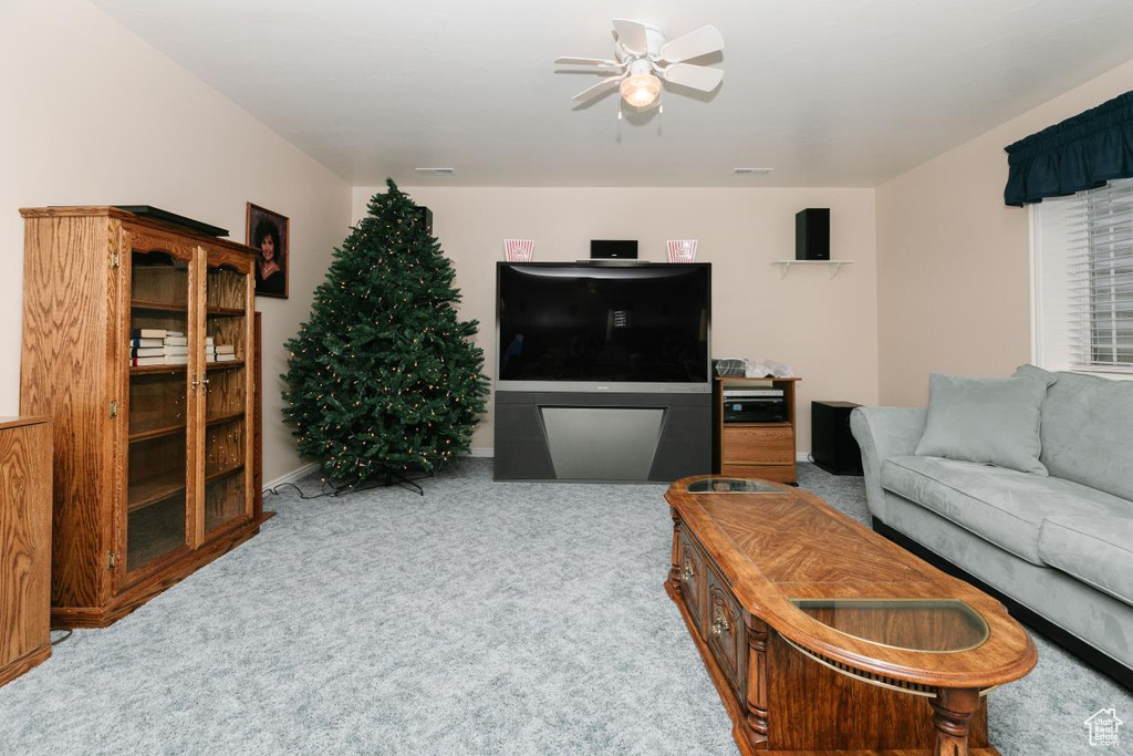 Living area featuring a ceiling fan and carpet flooring