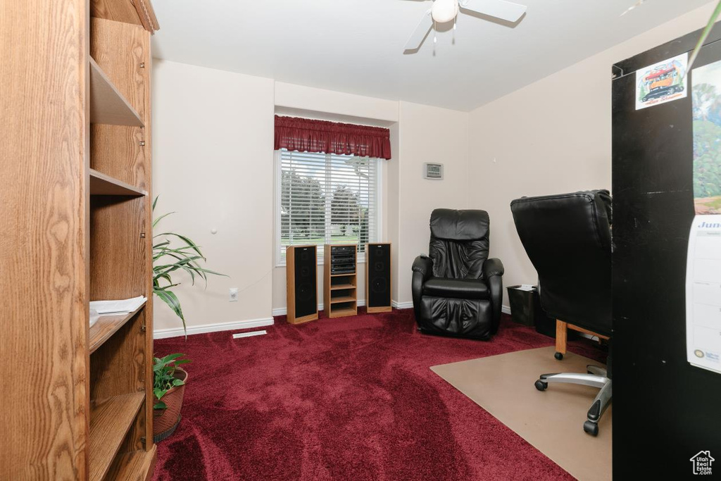 Carpeted office space with baseboards and a ceiling fan