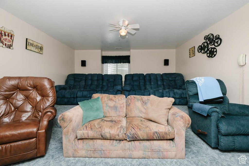 Carpeted living room featuring a ceiling fan