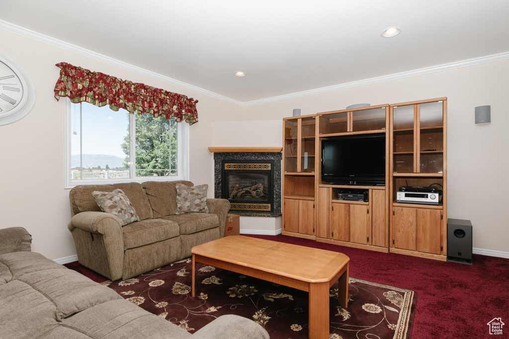 Living room featuring ornamental molding, a premium fireplace, baseboards, dark colored carpet, and recessed lighting