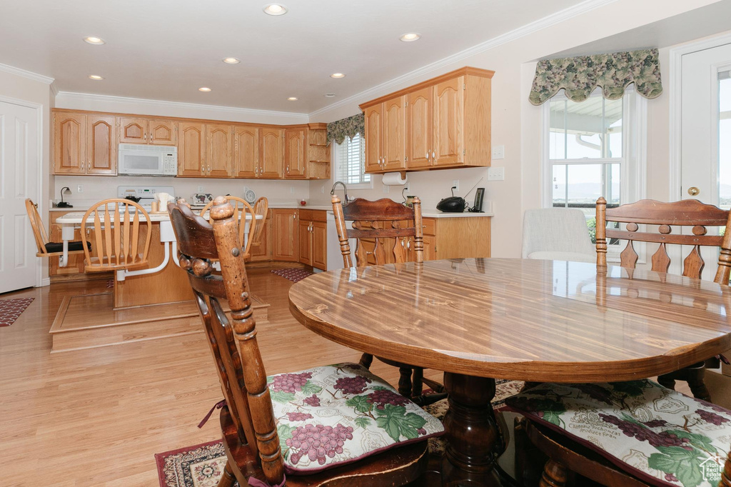 Dining space featuring crown molding, light wood-style floors, and recessed lighting