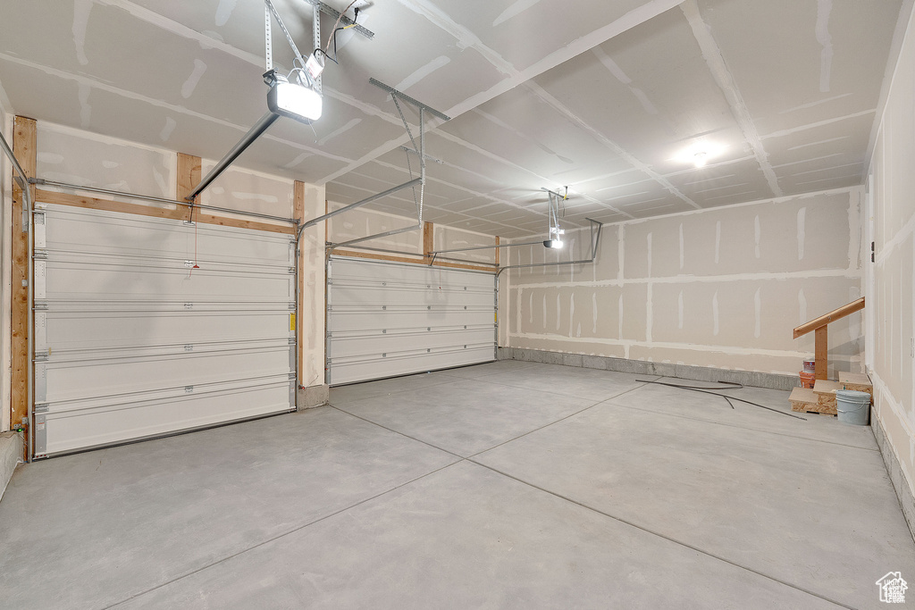 Garage with a garage door opener and baseboards