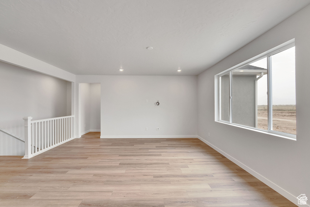 Unfurnished room with light wood finished floors, recessed lighting, and baseboards