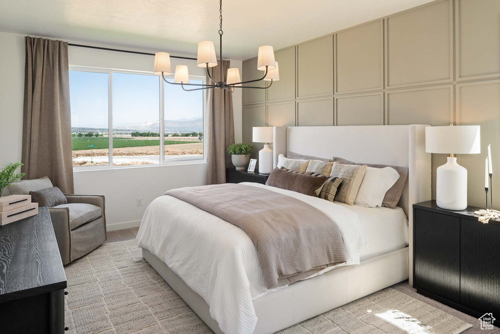 Bedroom with a chandelier, baseboards, and light colored carpet