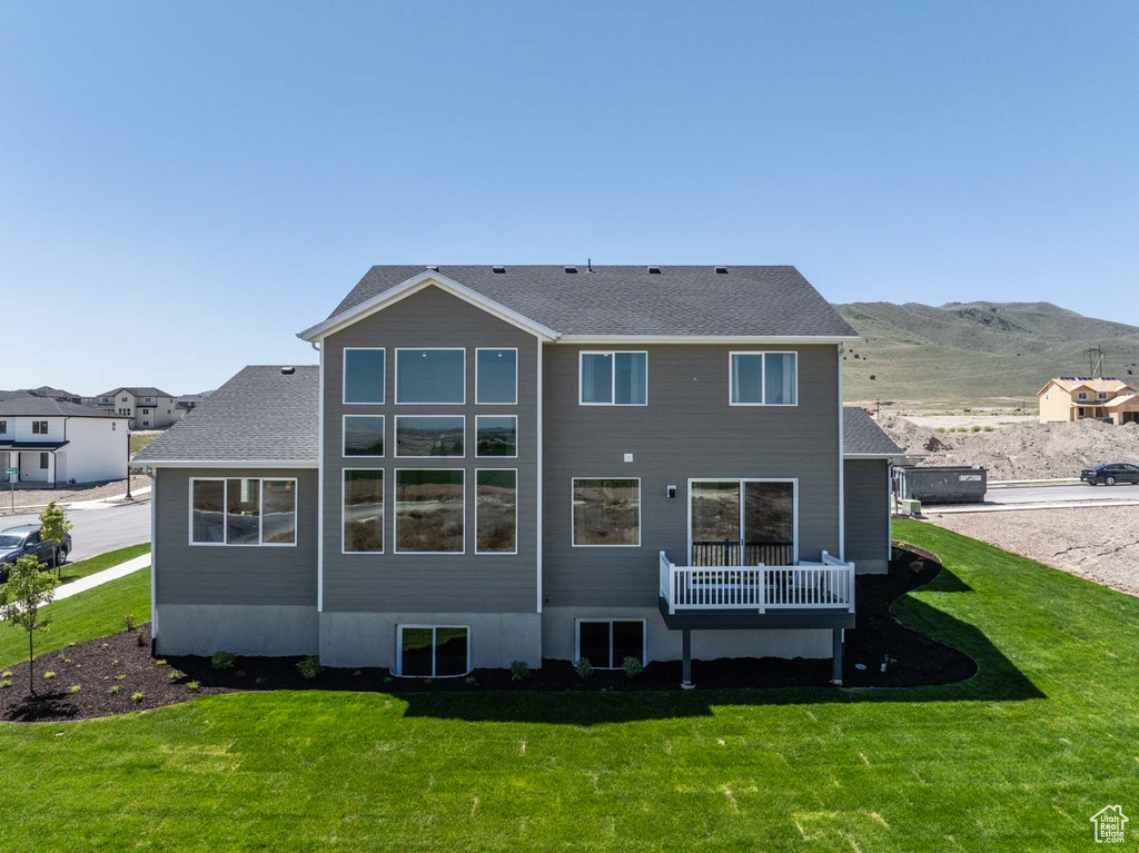 Rear view of house with a lawn and a mountain view