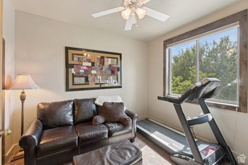 Living area featuring a ceiling fan and baseboards
