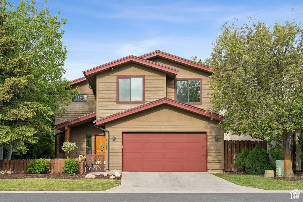 View of front of property with a garage and concrete driveway