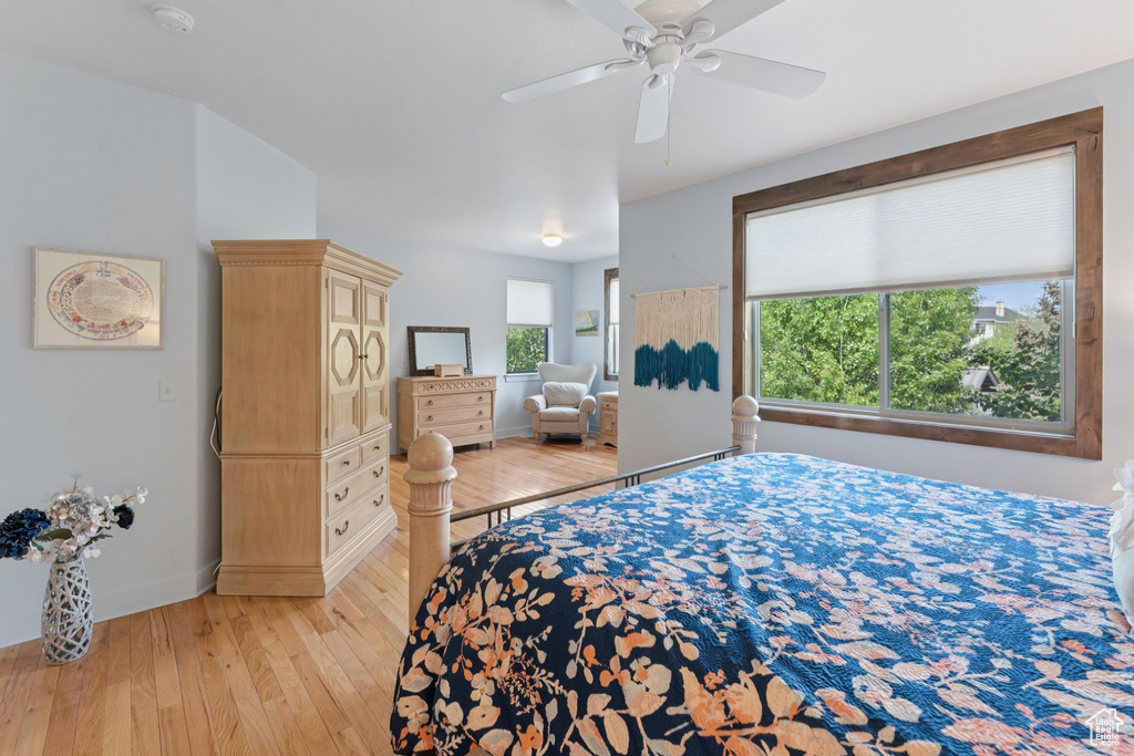 Bedroom featuring light wood finished floors, baseboards, and a ceiling fan