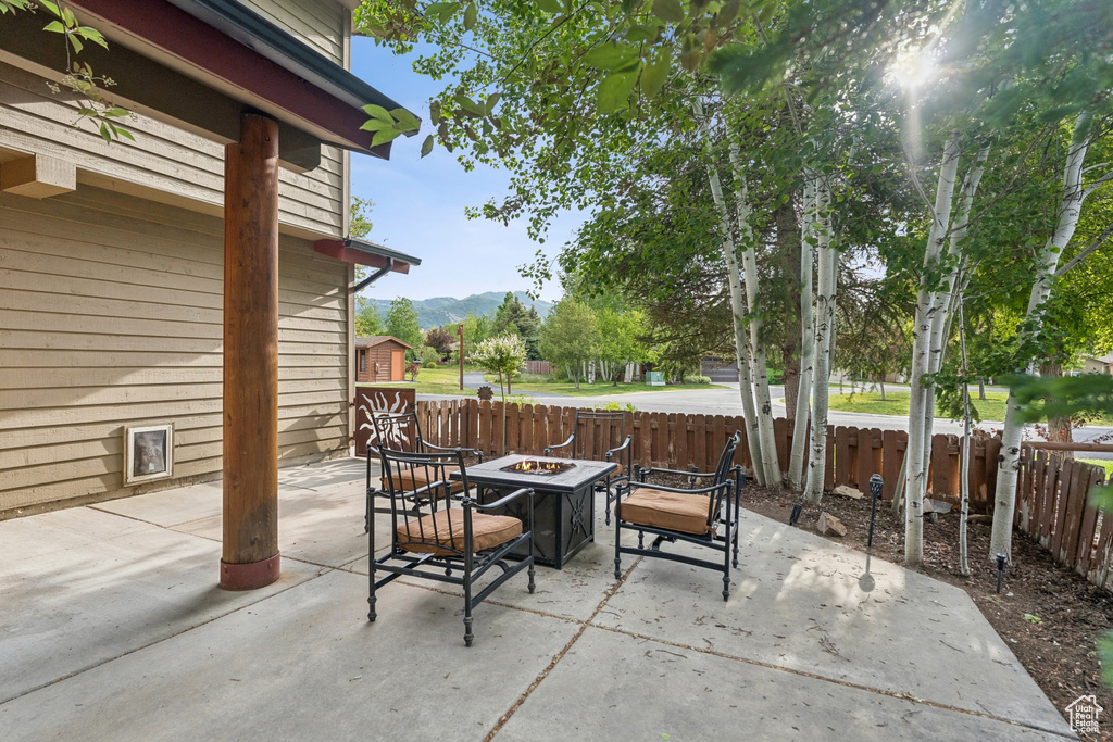 Fenced backyard featuring an outdoor fire pit, a mountain view, and a patio area