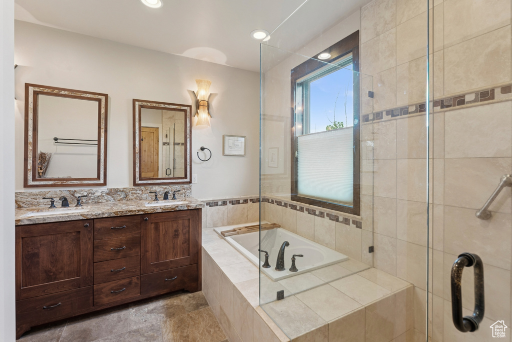Full bath featuring a garden tub, double vanity, and tiled shower