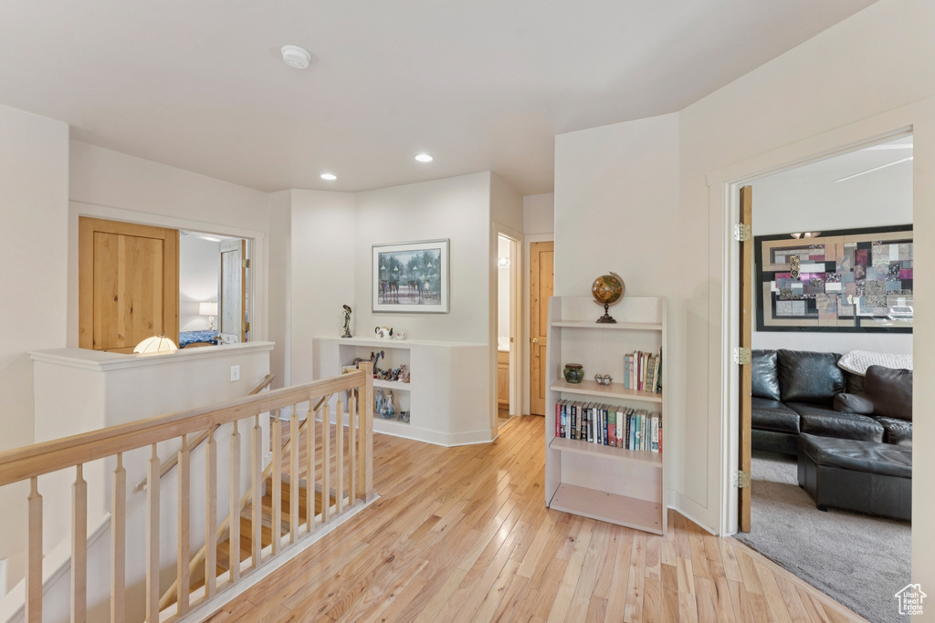 Hall featuring an upstairs landing, recessed lighting, wood-type flooring, and baseboards