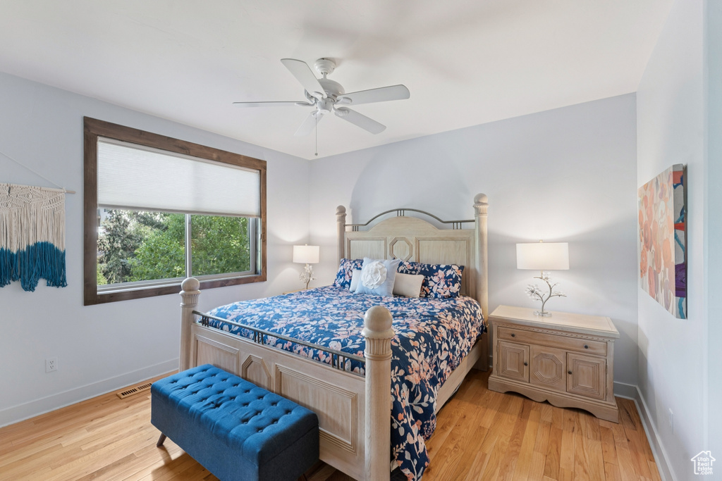 Bedroom with light wood-style floors, baseboards, and a ceiling fan