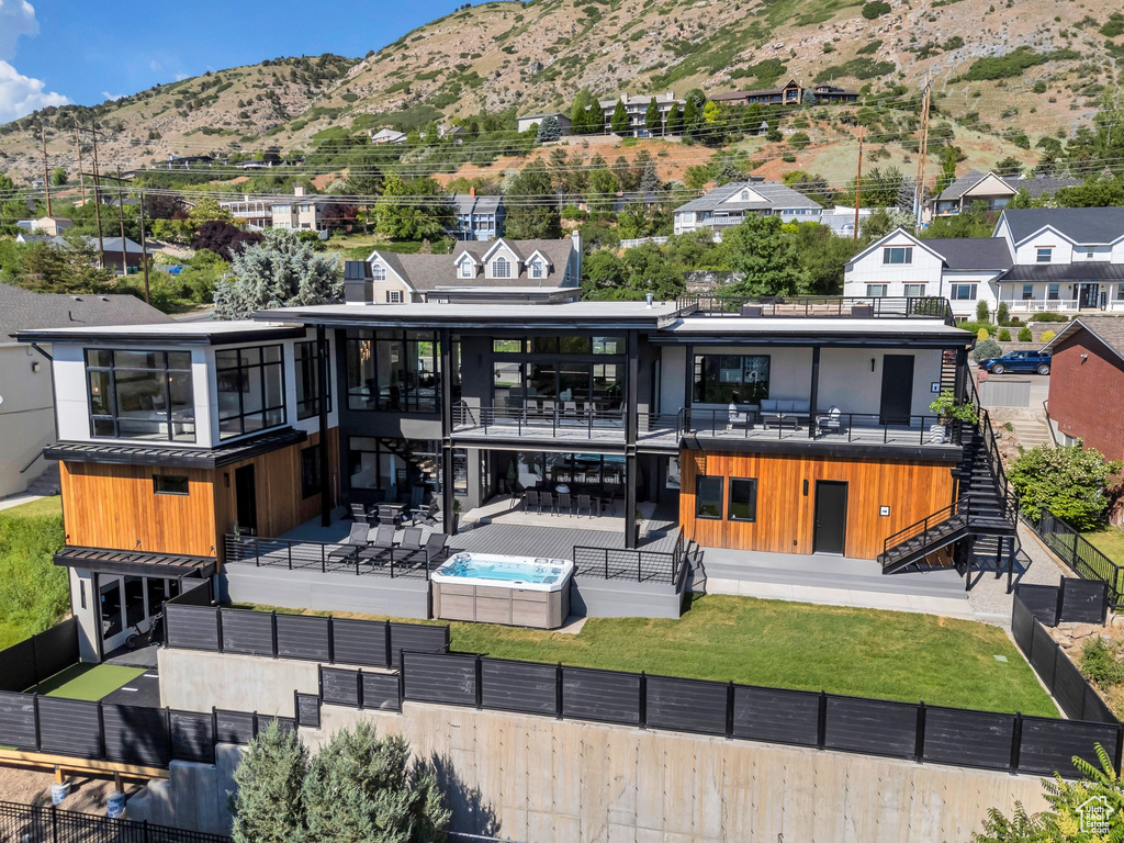 Rear view of property with stairs, a fenced backyard, a mountain view, a patio area, and a residential view