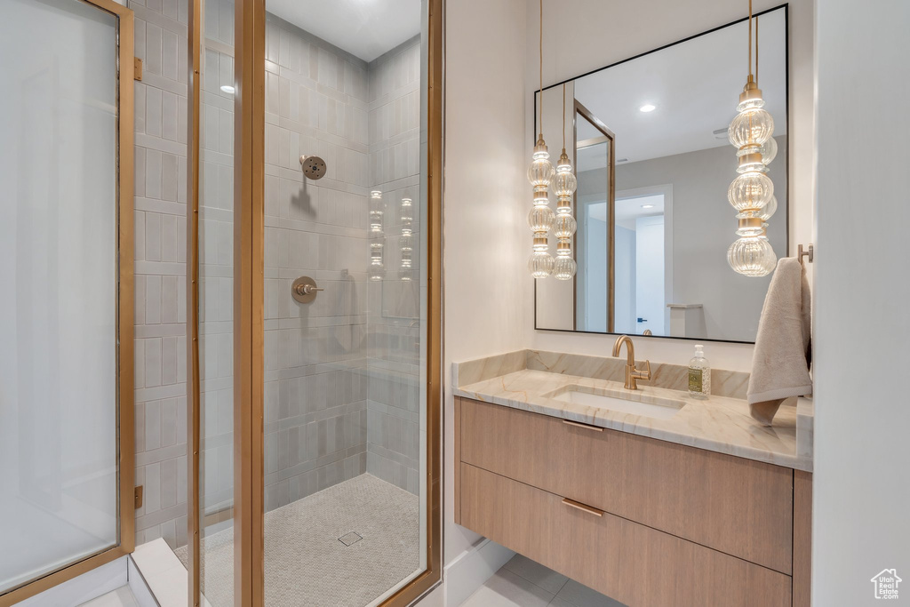 Bathroom with a stall shower, vanity, and tile patterned flooring