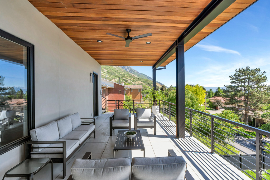 Balcony with an outdoor living space, a mountain view, and ceiling fan