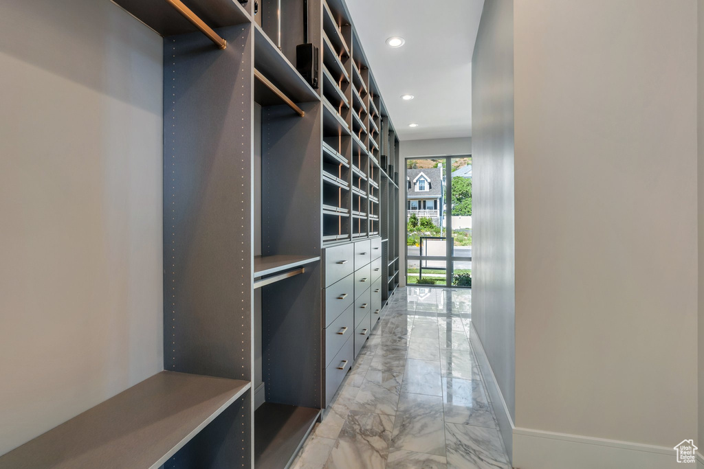 Walk in closet featuring light marble finish floors