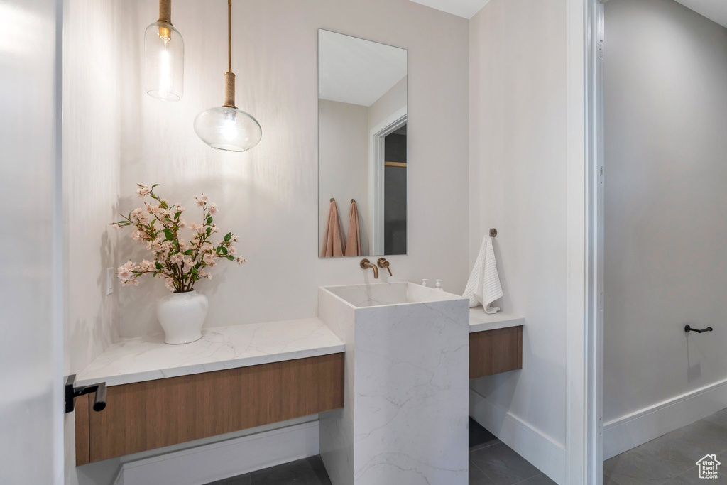 Bathroom featuring vanity, tile patterned floors, and baseboards