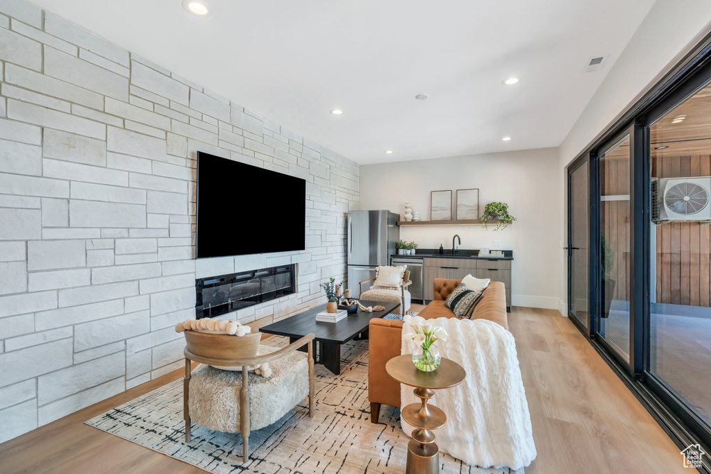 Living area featuring light wood-style floors, recessed lighting, a fireplace, and baseboards