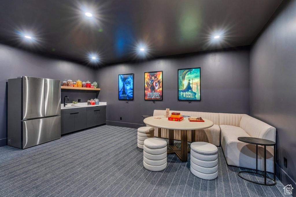 Rec room featuring dark carpet, recessed lighting, baseboards, and a sink
