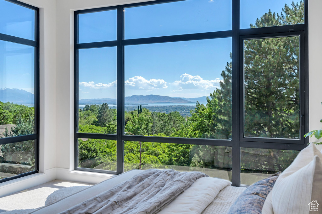 Bedroom featuring a mountain view and multiple windows