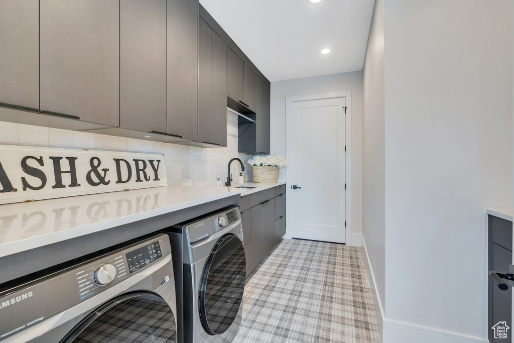 Washroom with cabinet space, separate washer and dryer, baseboards, and recessed lighting