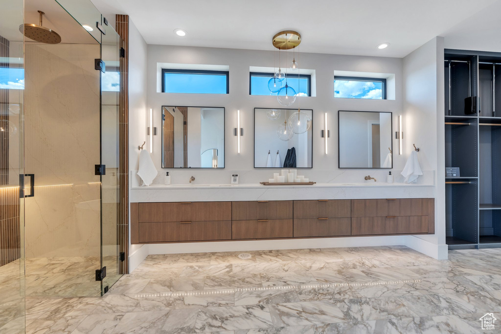 Bathroom with double vanity, a stall shower, marble finish flooring, and recessed lighting