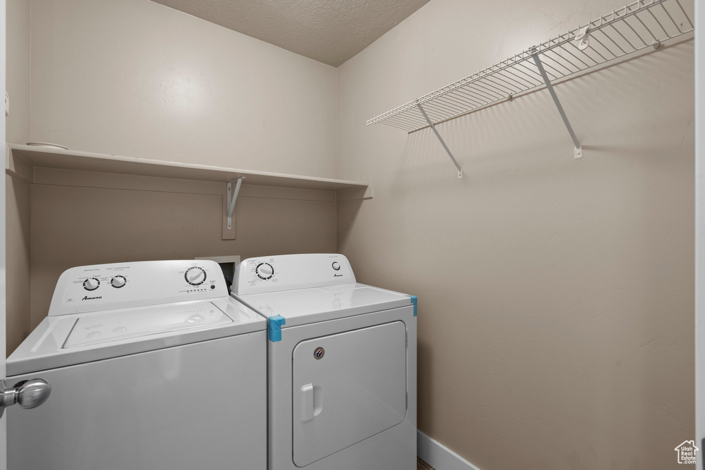 Laundry area with washing machine and clothes dryer and baseboards