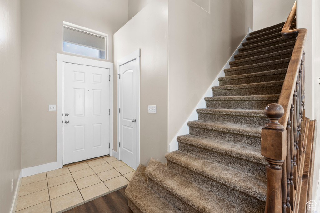 Entryway featuring stairway, tile patterned floors, and baseboards
