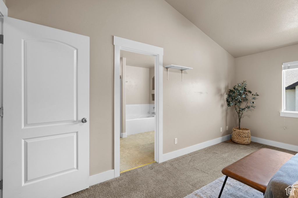 Living area featuring lofted ceiling, carpet floors, and baseboards