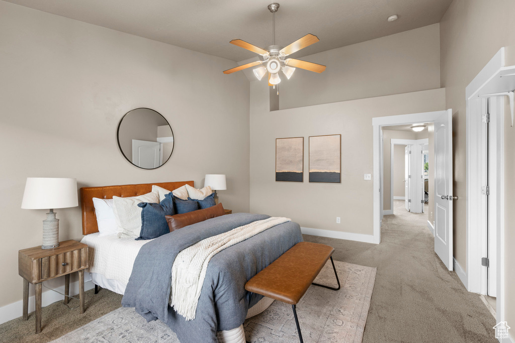 Carpeted bedroom featuring baseboards, high vaulted ceiling, and ceiling fan